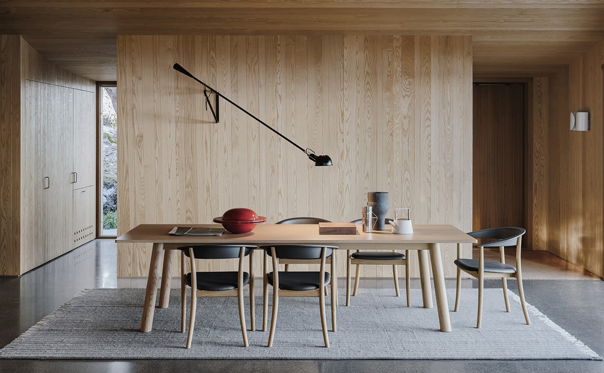 Modern dining room with wooden walls and minimalist decor.