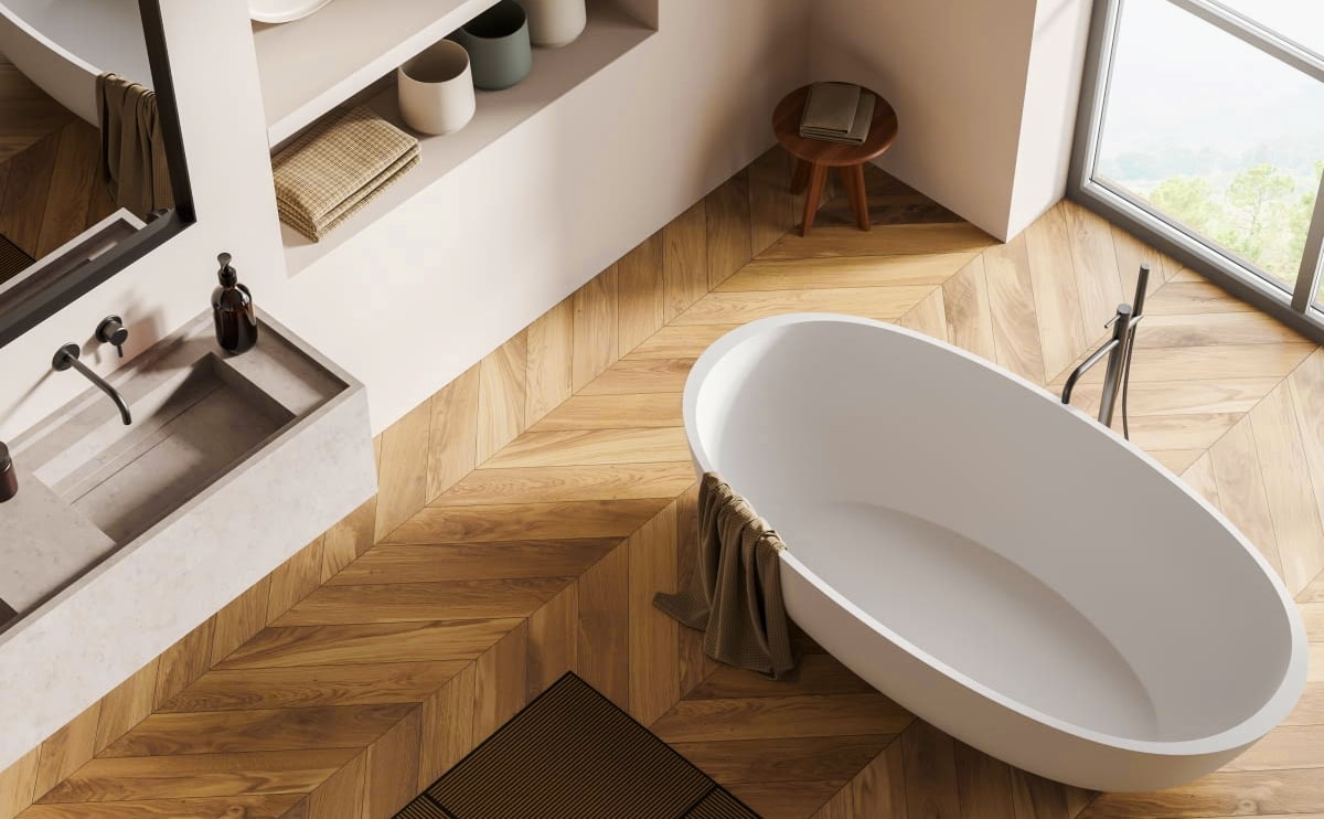 Modern bathroom with freestanding bathtub and wooden flooring.