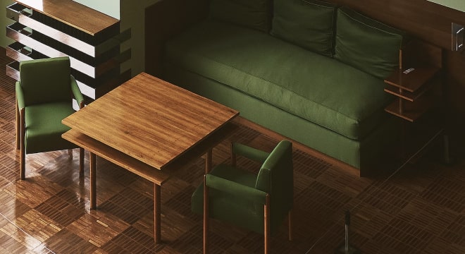 Modern dining area with wooden table and green upholstered chairs and sofa.