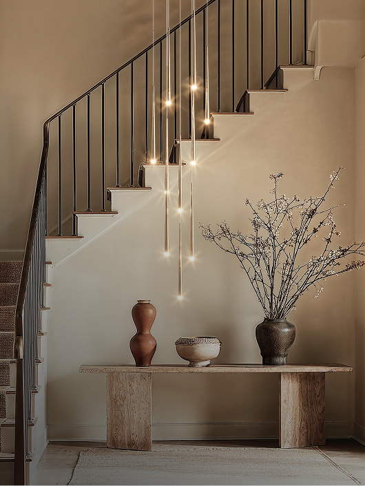 Elegant modern pendant lighting over a minimalist entryway table.