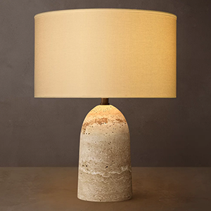 Modern table lamp with beige fabric shade and textured stone base.