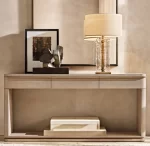 Elegant clear glass table lamp with fabric shade on console table.
