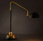 Modern black and gold task table lamp with adjustable arm and shade.