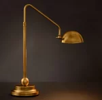 Elegant gold task table lamp with adjustable arm and dome shade for modern decor.