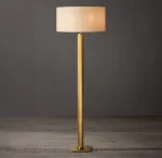 Elegant gold floor lamp with a white lampshade for modern interiors.