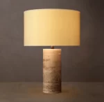Gorvey stone cylindrical table lamp with beige lampshade and stone base.