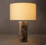 Elegant stone cylindrical table lamp with beige lampshade for modern decor.