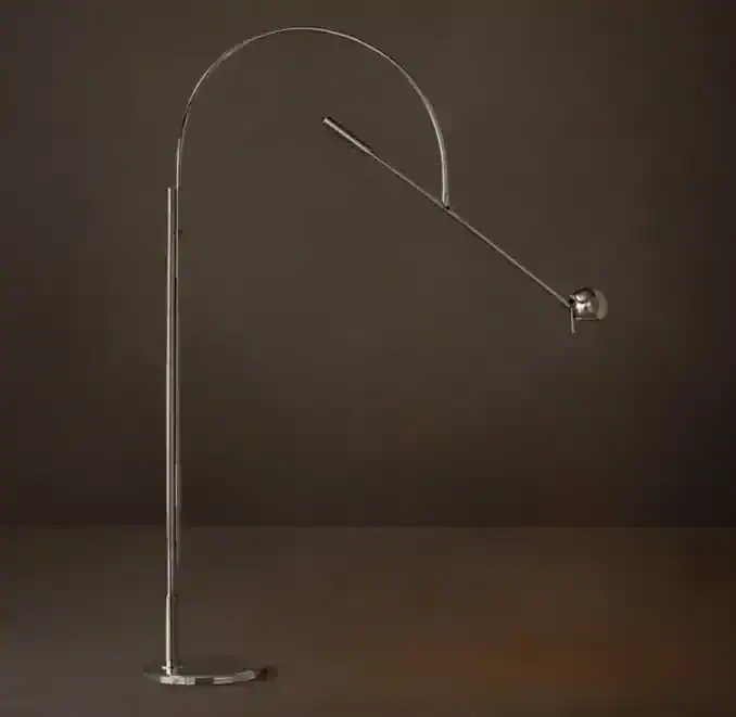 Modern metallic arc floor lamp with adjustable arm and spherical base.
