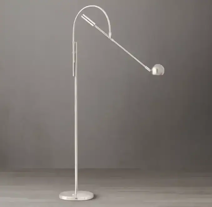 Modern minimalist floor lamp with adjustable arm and spherical light fixture.