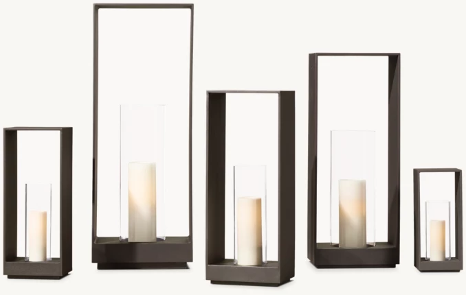 Modern black metal candle lanterns with white candles for home decor.