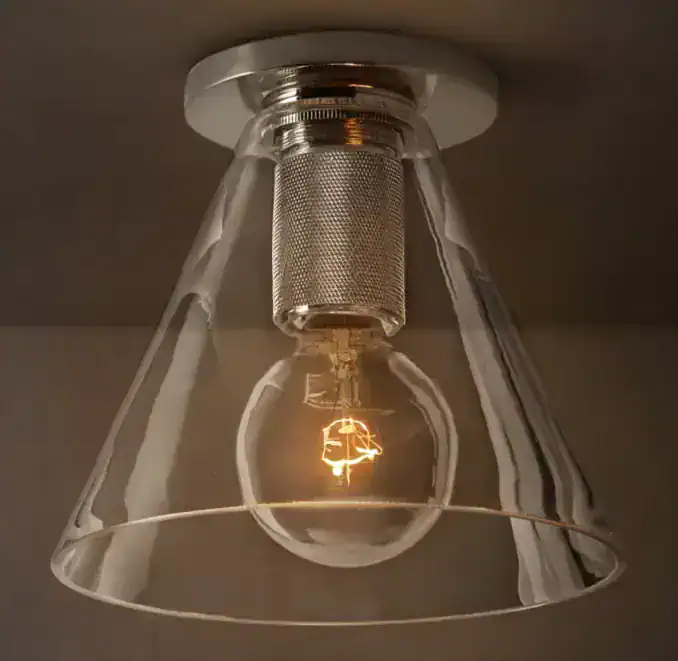 Contemporary ceiling light fixture with exposed filament bulb and glass shade.