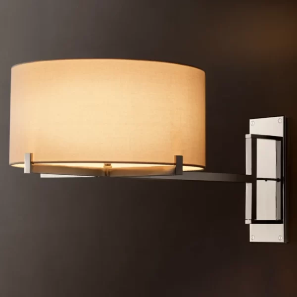 Modern wall sconce with beige fabric shade and black metal arm.