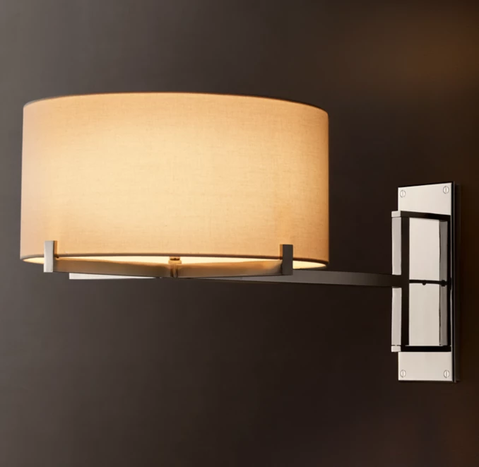 Modern wall sconce with beige fabric shade and black metal arm.