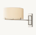 Contemporary wall-mounted lamp with beige shade and sleek metal arm.