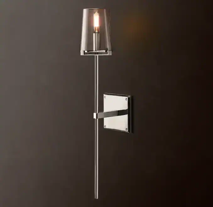 Contemporary wall-mounted light with metallic finish and clear shade.