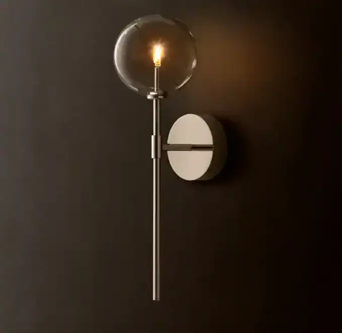 Contemporary wall-mounted light with glass globe and sleek metal design.