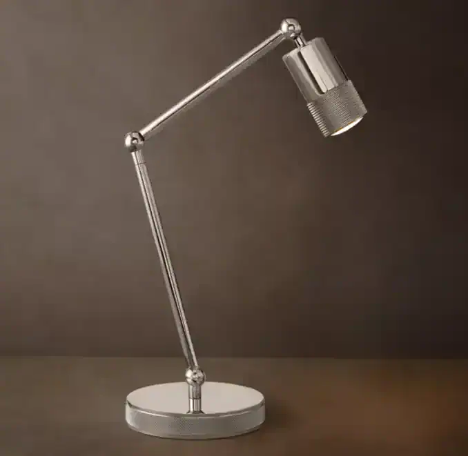 Modern metallic desk lamp with adjustable arm and cylindrical shade.