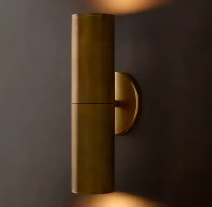 Elegant gold wall lamp by Gorvey Lighting with warm ambient glow.