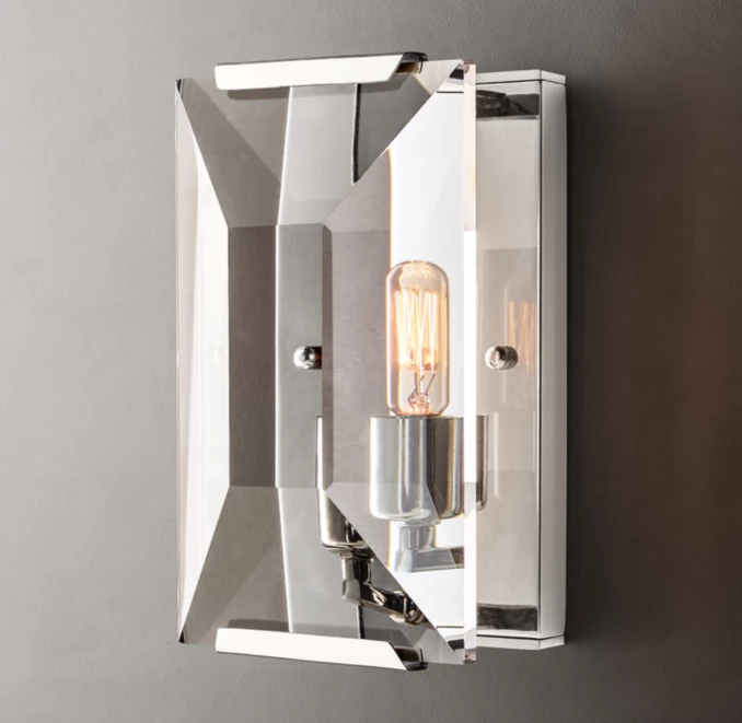Contemporary wall sconce with sleek metallic finish and exposed filament bulb.