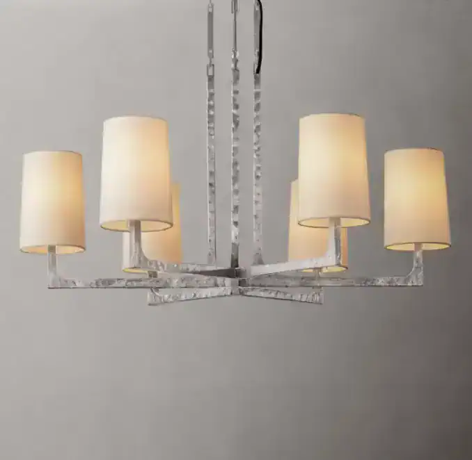 Modern chandelier with six cream lampshades and metallic frame.