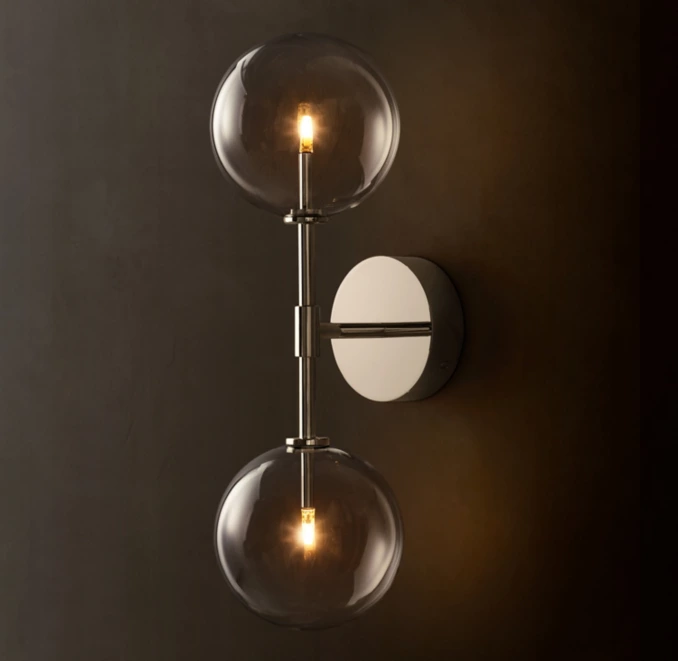 Contemporary wall lamp with glass globes and warm LED lighting.