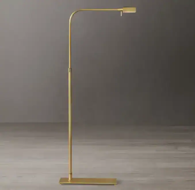 Elegant gold floor lamp with adjustable reading light for modern interiors.