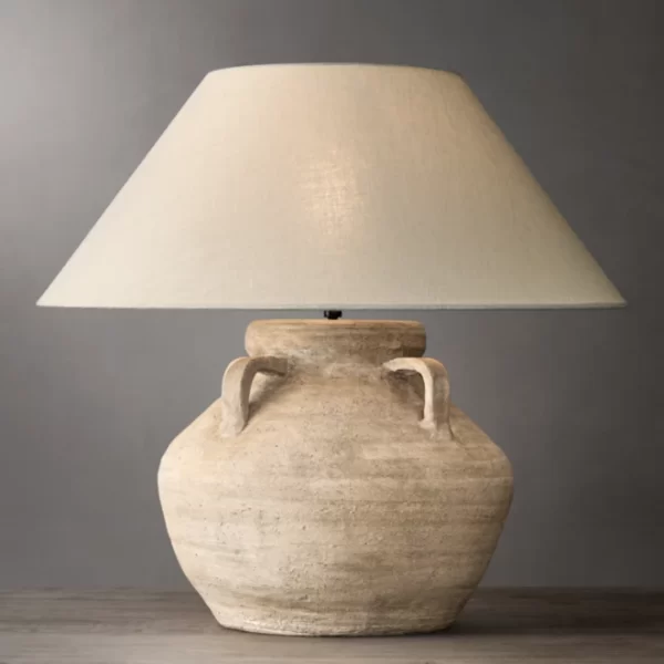 Ceramic table lamp with a beige lampshade and rustic finish.