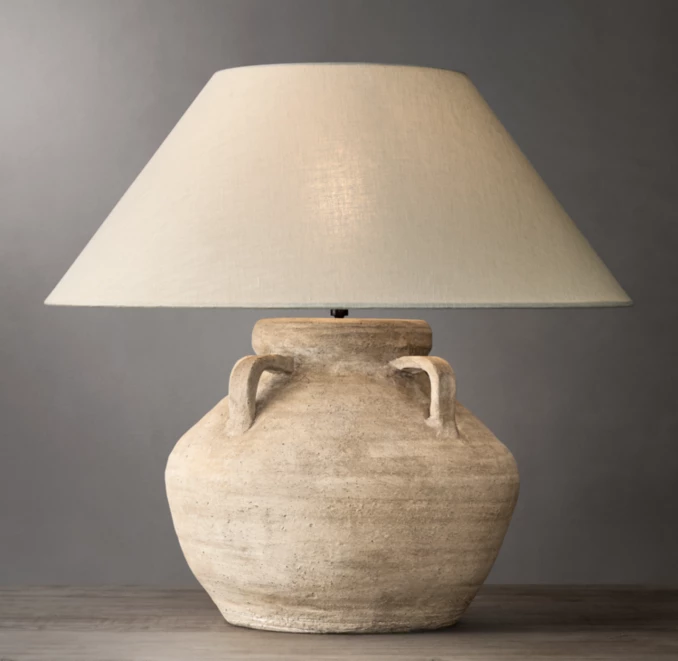 Ceramic table lamp with a beige lampshade and rustic finish.