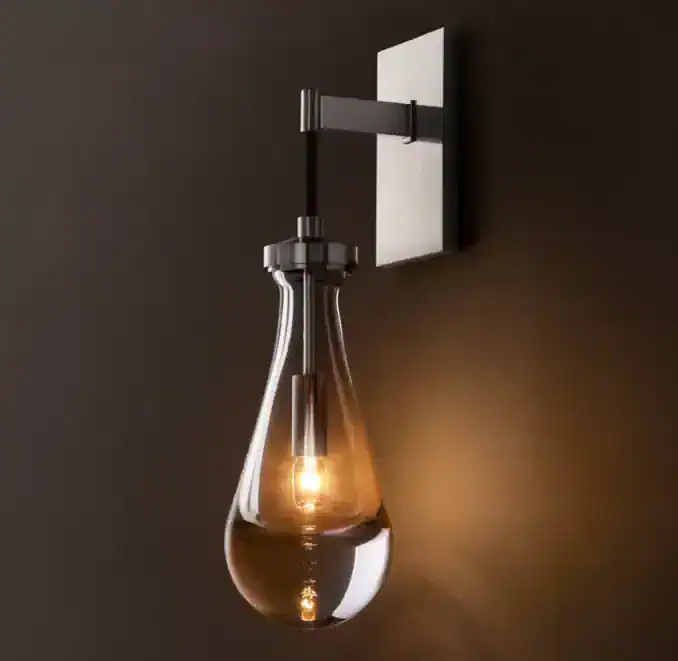 Contemporary wall-mounted light fixture with a glass teardrop shade.