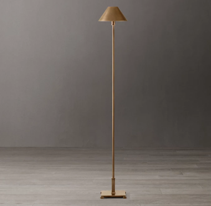 Elegant gold floor lamp with beige lampshade in modern interior.