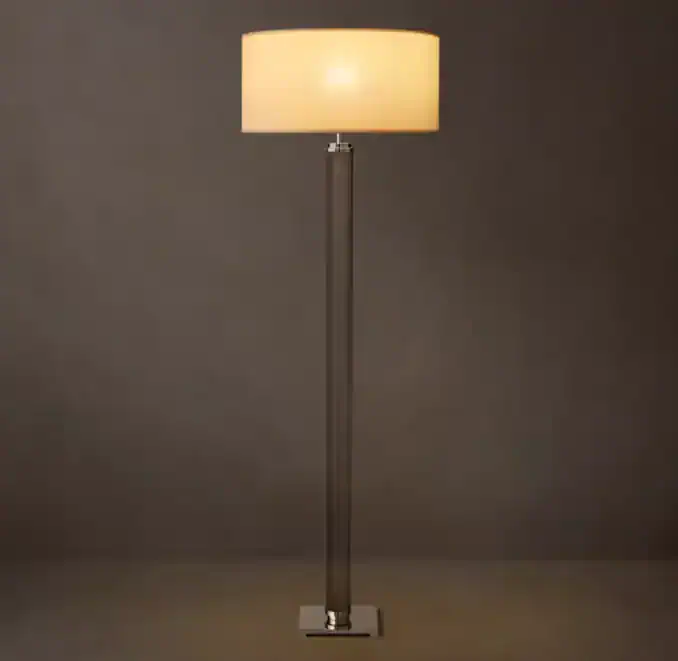 Elegant floor lamp with cylindrical glass column and soft beige lampshade.