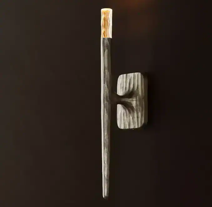 Unique forged metal sconce with a modern design for wall lighting.