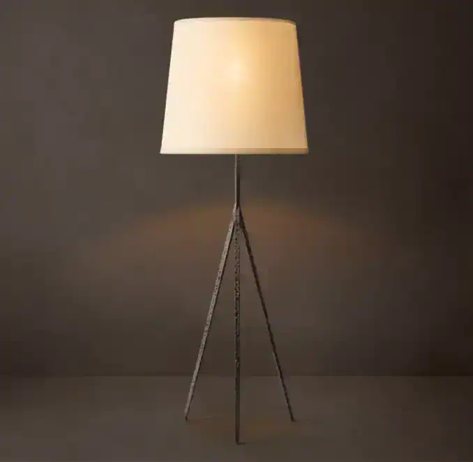 Modern tripod floor lamp with beige lampshade and black tripod stand.