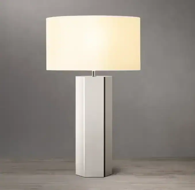 Modern hexagonal table lamp with white shade and sleek base for stylish lighting.