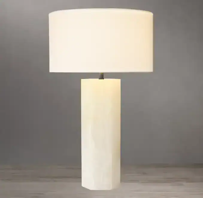 Elegant white stone table lamp with cylindrical base and oval shade.