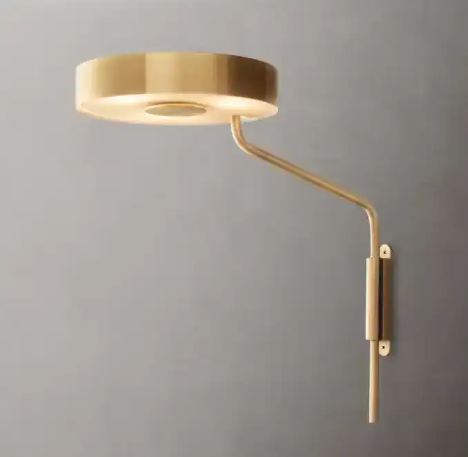 Modern brass task sconce with adjustable drum shade for versatile lighting.