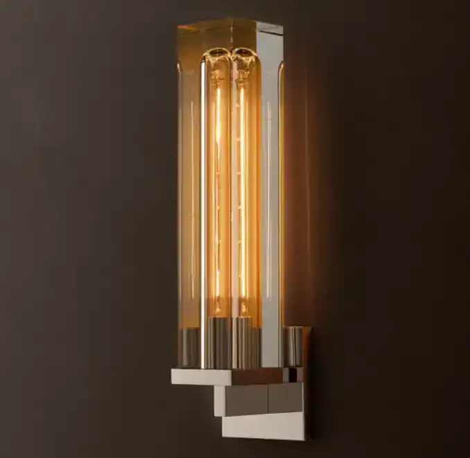 Modern brass and glass wall sconce with warm lighting from Gorvey Lighting.