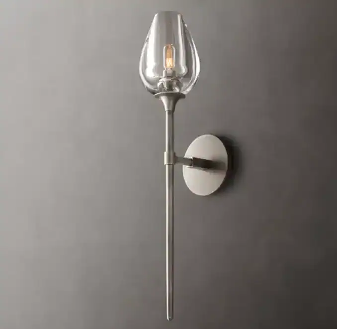 Modern wall sconce with glass shade and brass finish for elegant lighting.