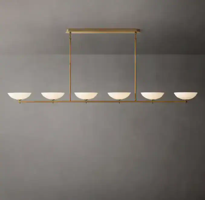 Modern linear chandelier with brass finish and white glass shades.