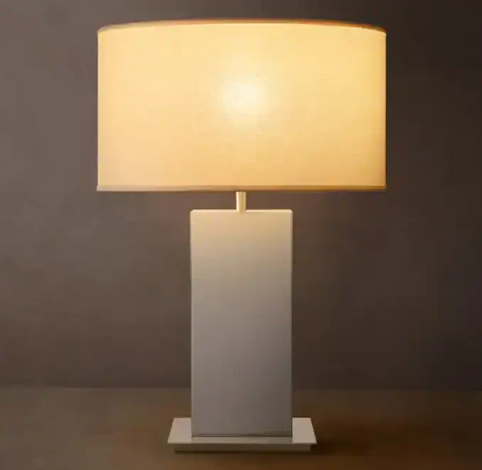 Modern steel table lamp with beige lampshade for home decor.