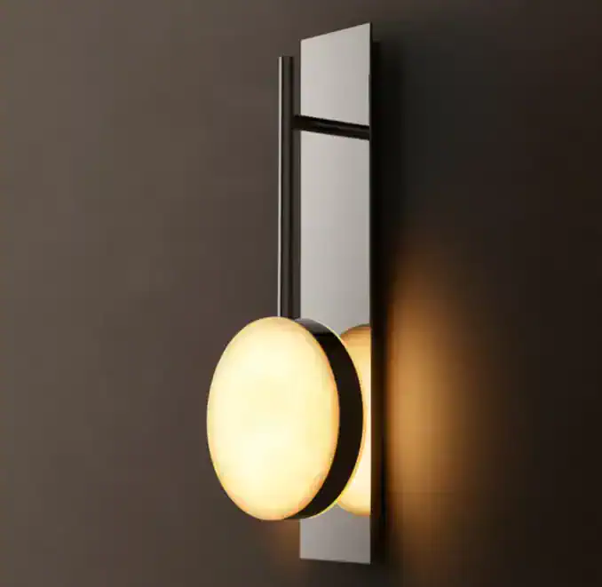 Modern alabaster wall sconce with black metal accents for elegant lighting.