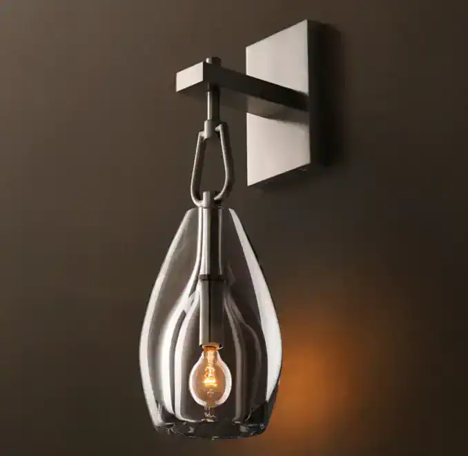 Modern wall sconce with glass shade and exposed bulb for stylish lighting.