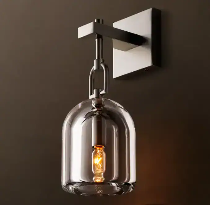 Modern glass sconce with exposed filament bulb for stylish lighting.