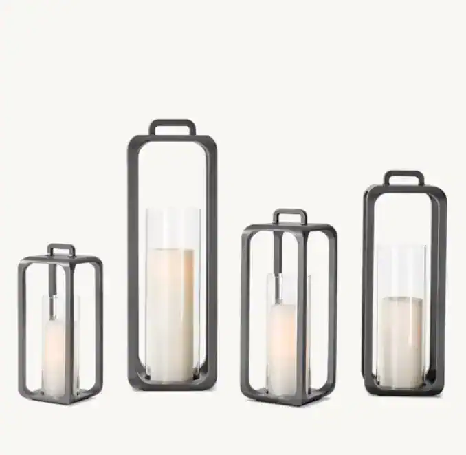 Set of modern metal lanterns with glass hurricane shades for home decor.