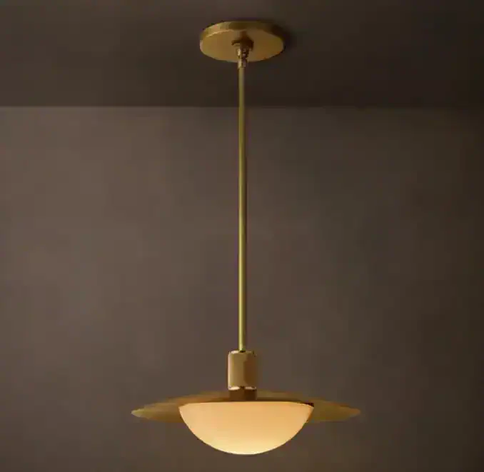 Brass glass pendant light hanging from ceiling in modern interior.