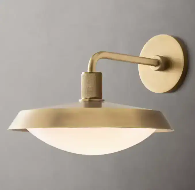 Brass barn sconce with milk glass shade for vintage lighting.