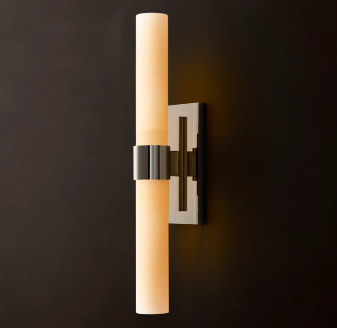 Modern wall sconce with cylindrical light and black metal mount.