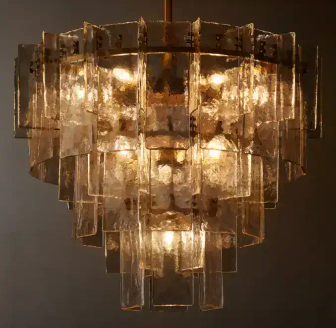 Elegant tiered glass chandelier with warm lighting from Gorvey Lighting.