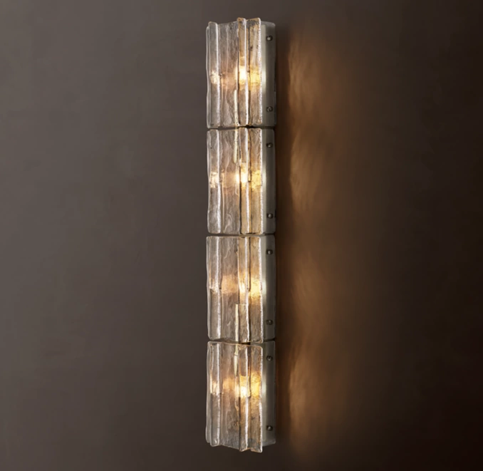 Modern glass sconce with lattice design and warm lighting.