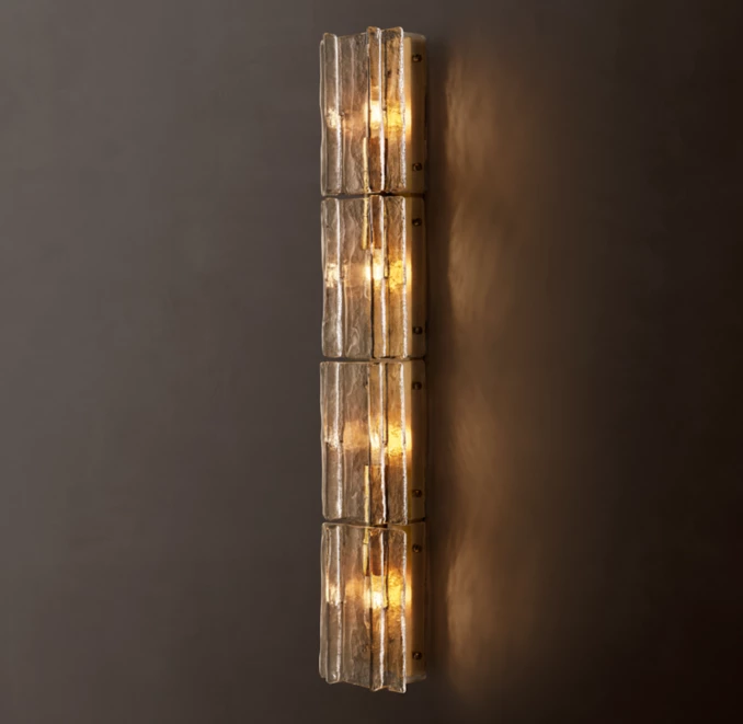 Modern glass sconce with warm lighting in smoke cast glass finish.